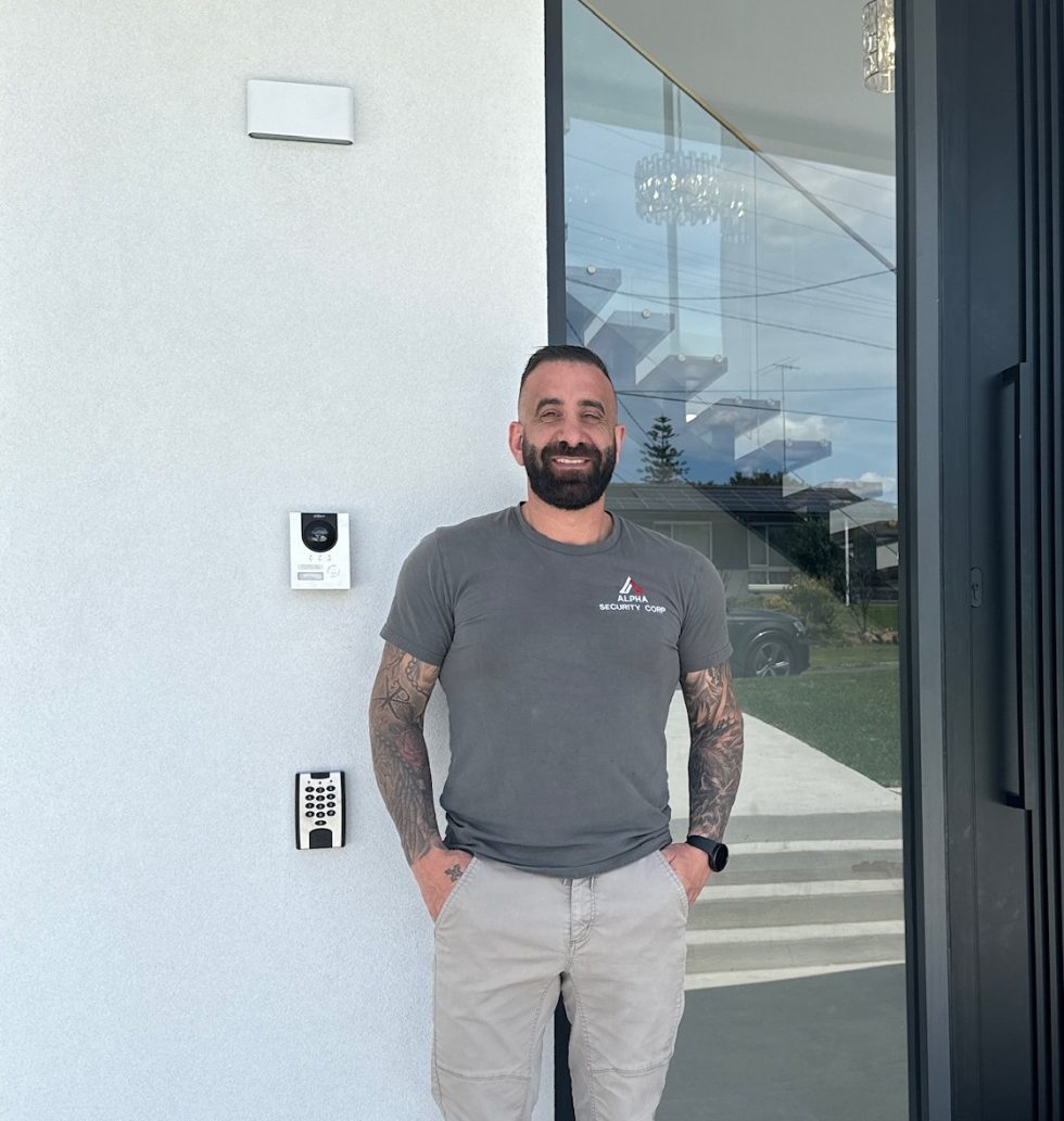 Tom Khawly from Alpha Security Corp standing beside an installed intercom and access control system